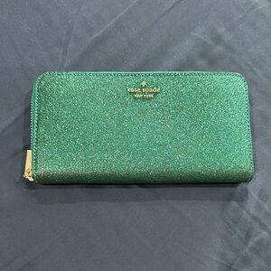 kate spade glitter zip-around wallet in emerald green with gold logo